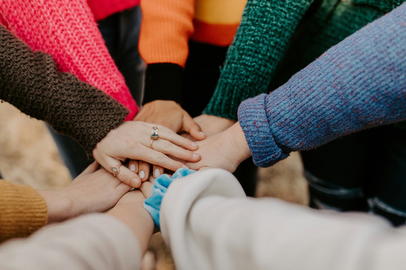 A group of people stacking their hands together in unity